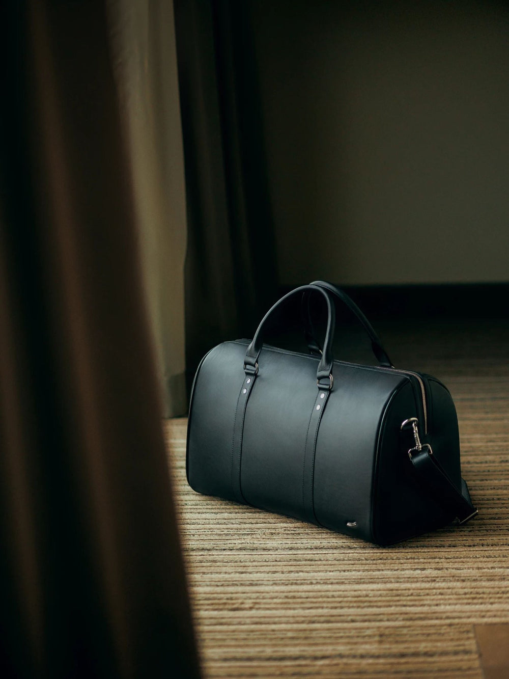 f34 duffle bag black leather on the floor